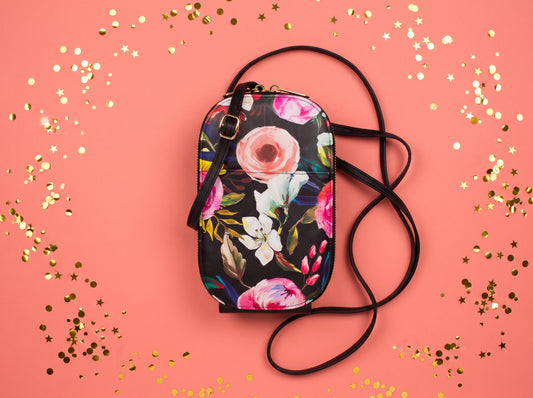 Monarque Floral on Black phone crossbody bag on coral background with gold confetti