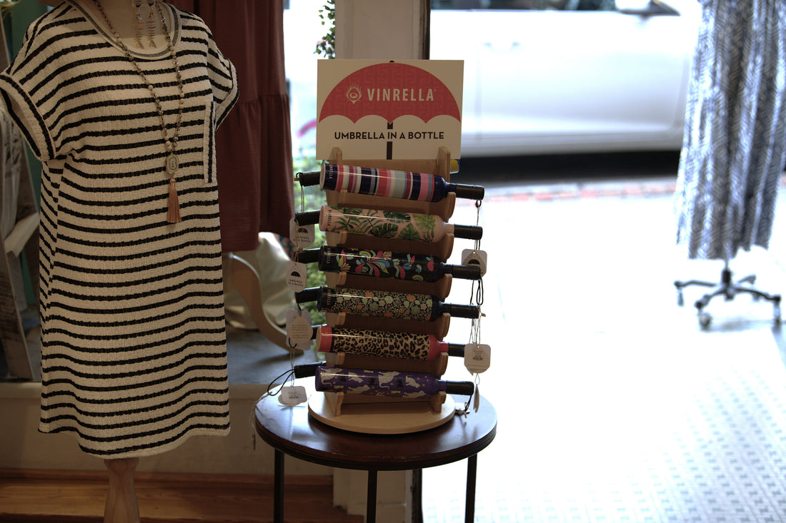 A Vinrella umbrella display positioned by a retail store's front door.