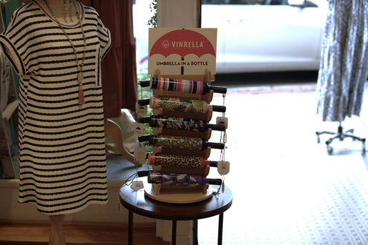 A Vinrella umbrella display positioned by a retail store's front door.