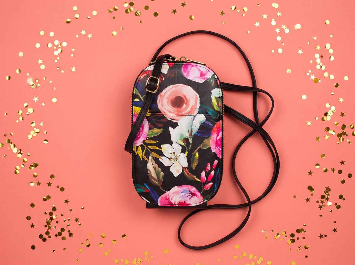 Monarque Floral on Black phone crossbody bag on coral background with gold confetti